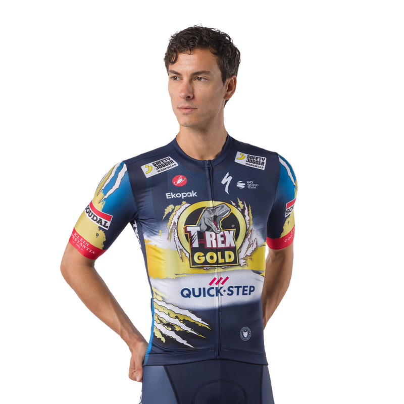 A male cyclist wearing a navy blue, yellow, and white sponsor cycling jersey with 'T-rex Gold' and 'Quick-Step' logos, photographed against a solid white background.